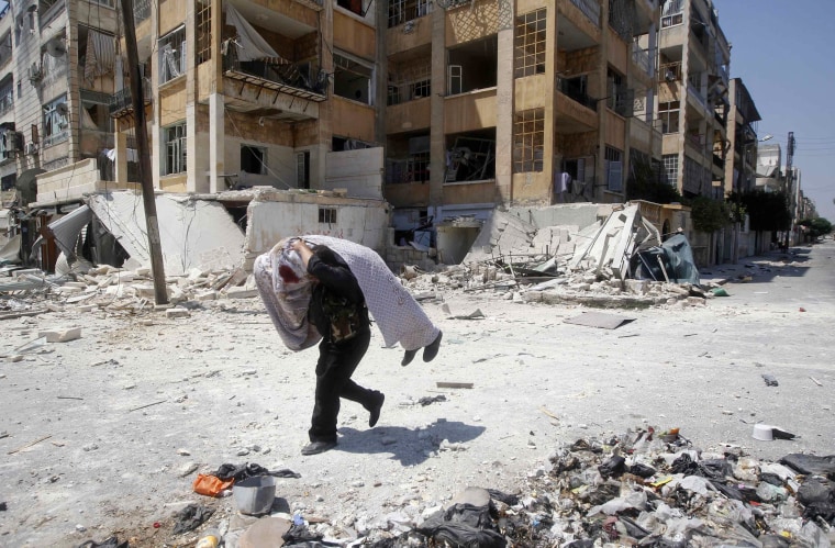 Image: A Free Syrian Army fighter carries the body of a fellow fighter during clashes in Aleppo